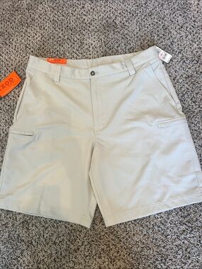 NWT Men's Izod XFG flat front golf shorts. Size 38. 9 inch inseam. Color is khak